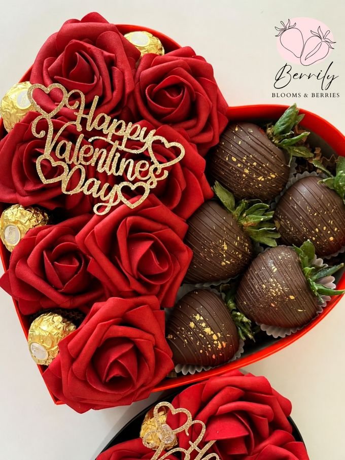 Caja en forma de corazón con rosas rojas, bombones y fresas cubiertas de chocolate oscuro